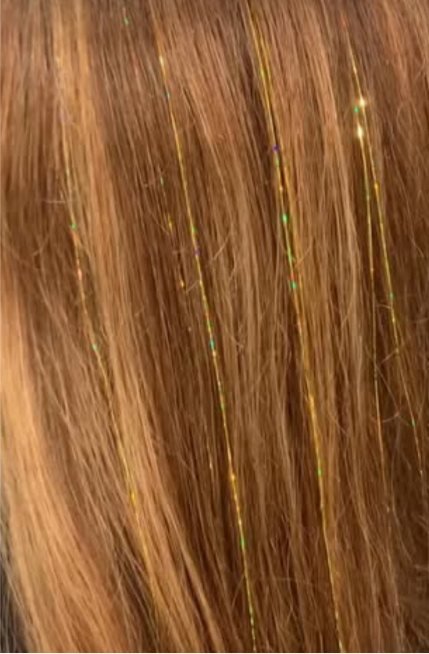 Golden hair tinsel sparkling in warm blonde hair